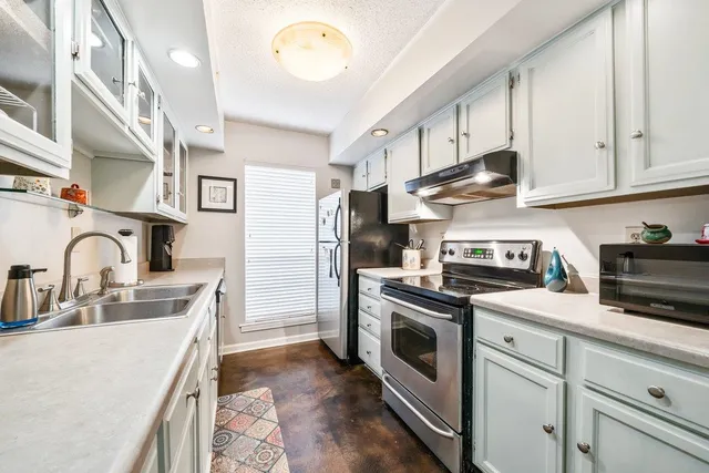 a kitchen with stainless steel appliances granite countertop a stove a sink dishwasher and a refrigerator
