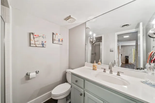 a bathroom with a toilet a sink and mirror