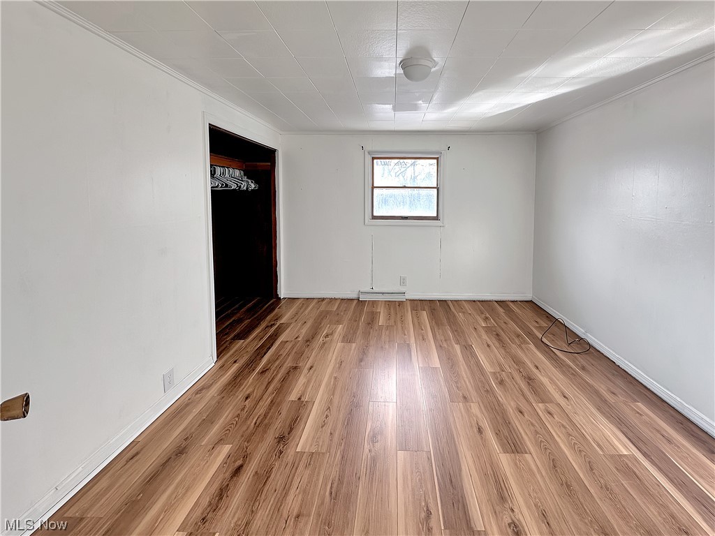 2692 Race Track Road New Cumberland, WV 26047 - Photo 16 of 25 Spare room with crown molding, a baseboard heating unit, and light wood-type flooring