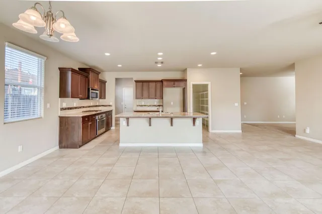 a large kitchen with a large counter top stainless steel appliances and cabinets
