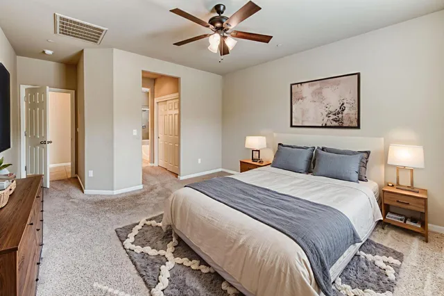 a spacious bedroom with a bed and a chandelier