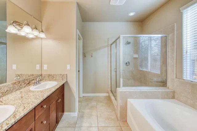 a bathroom with a granite countertop sink mirror and a bathtub