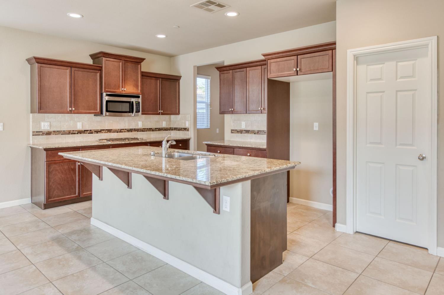 3460 Griffith Avenue Clovis, CA 93619 - Photo 8 of 28 a kitchen that has a sink and a stove in it