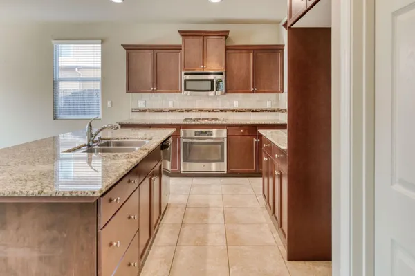a kitchen with granite countertop a stove top oven cabinetry and granite counter tops
