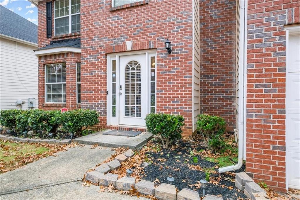a view of a brick house with plants