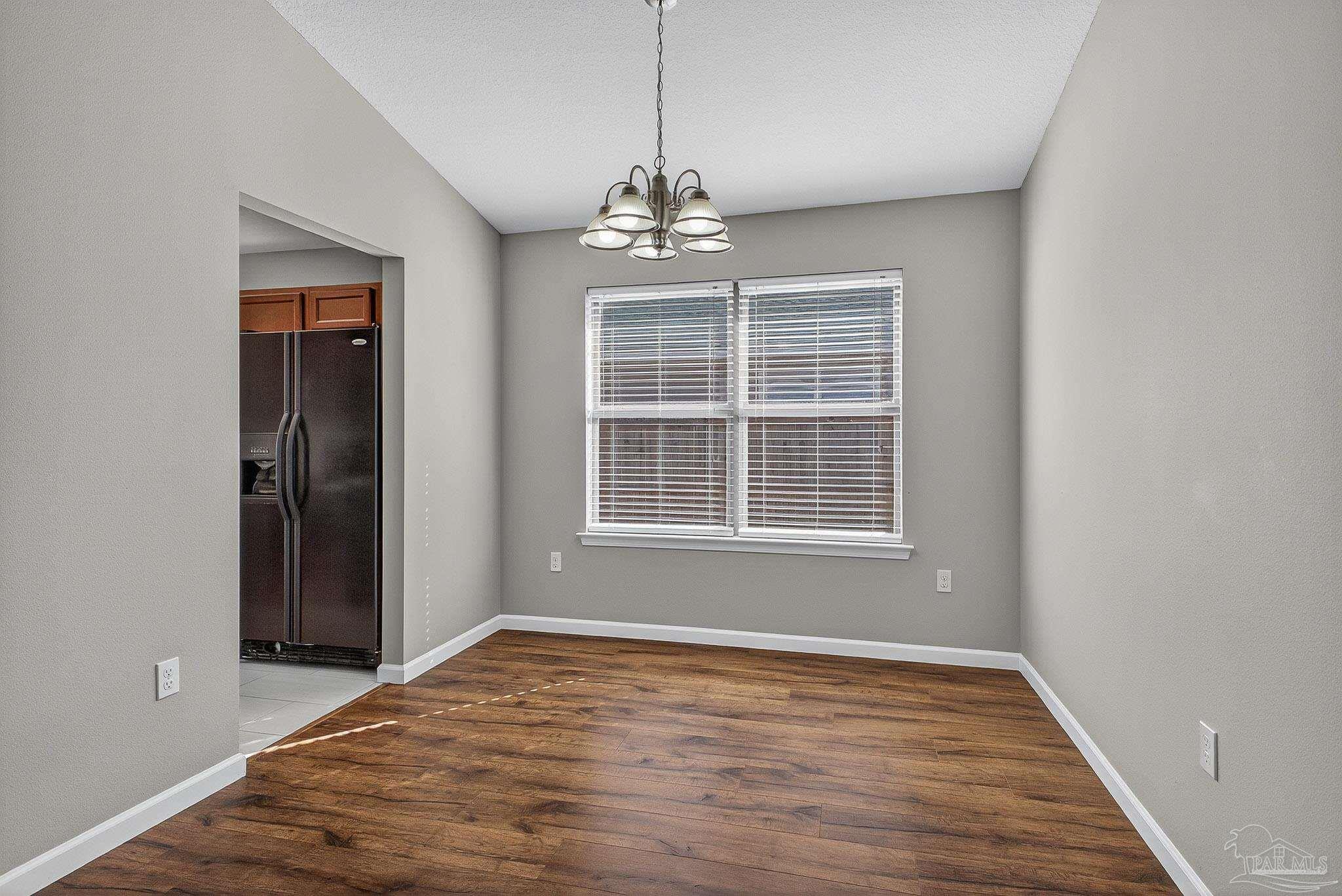 272 Millet Circle Cantonment, FL 32533 - Photo 13 of 57 an empty room with wooden floor cabinet and windows