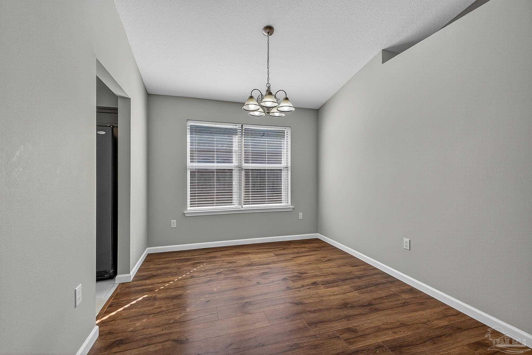 272 Millet Circle Cantonment, FL 32533 - Photo 14 of 57 a big room with wooden floor a ceiling fan and windows
