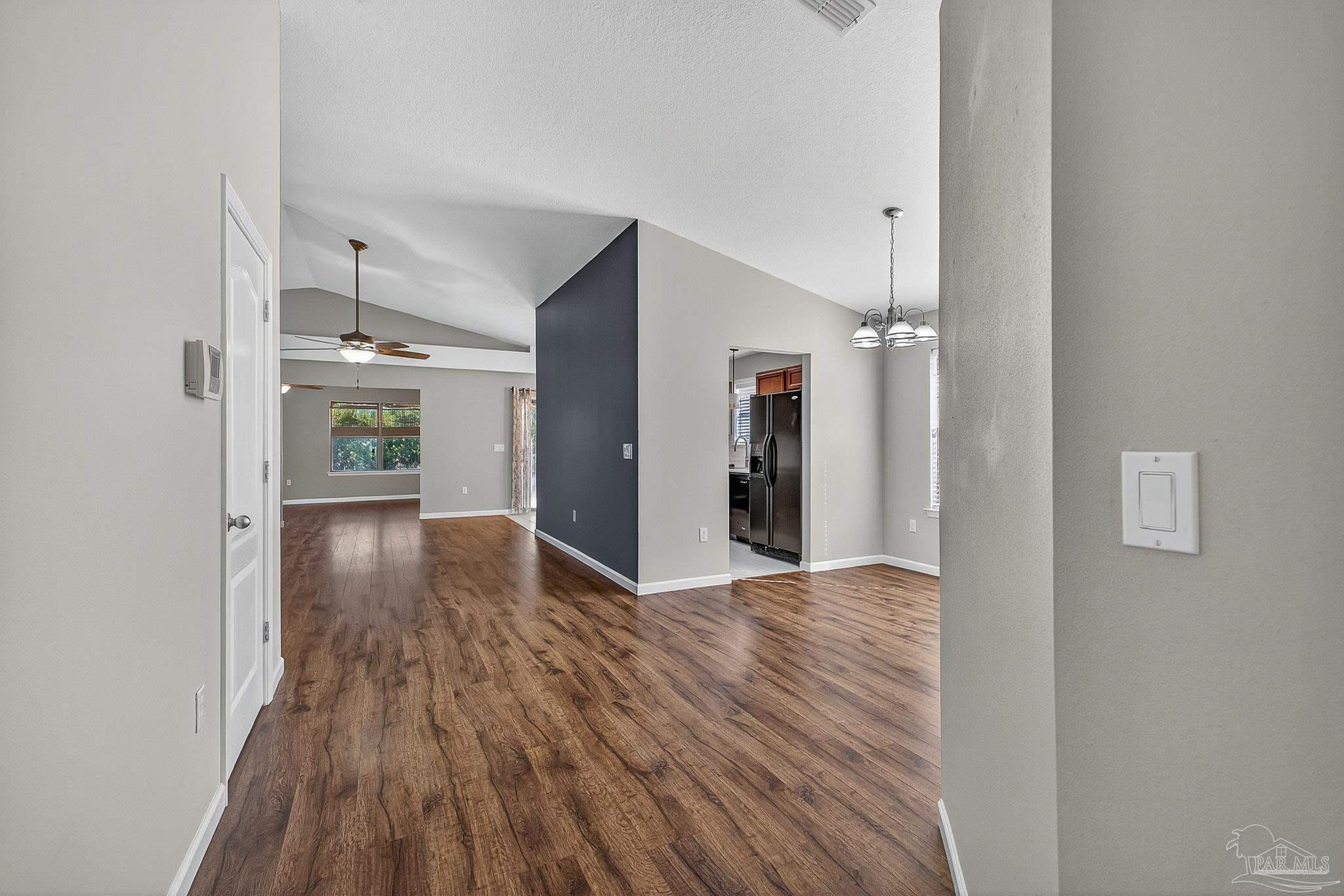 272 Millet Circle Cantonment, FL 32533 - Photo 17 of 57 a view of a hallway with wooden floor and a refrigerator