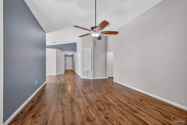 a view of a room with wooden floors ceiling fan