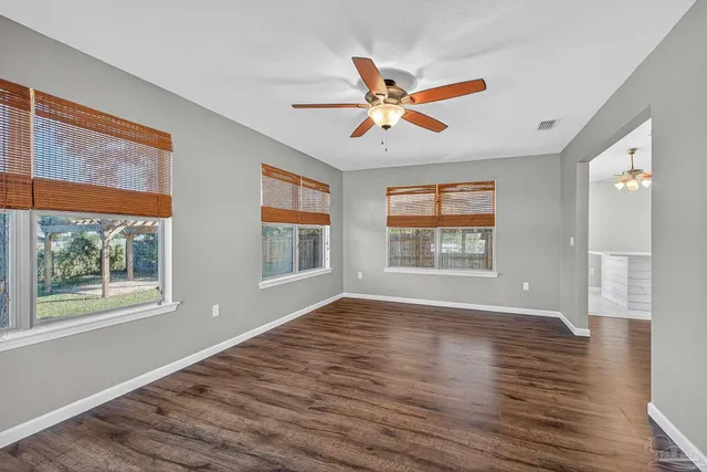 a view of an empty room with wooden floor
