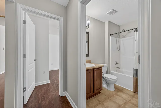 a bathroom with a granite countertop double vanity sink and a mirror