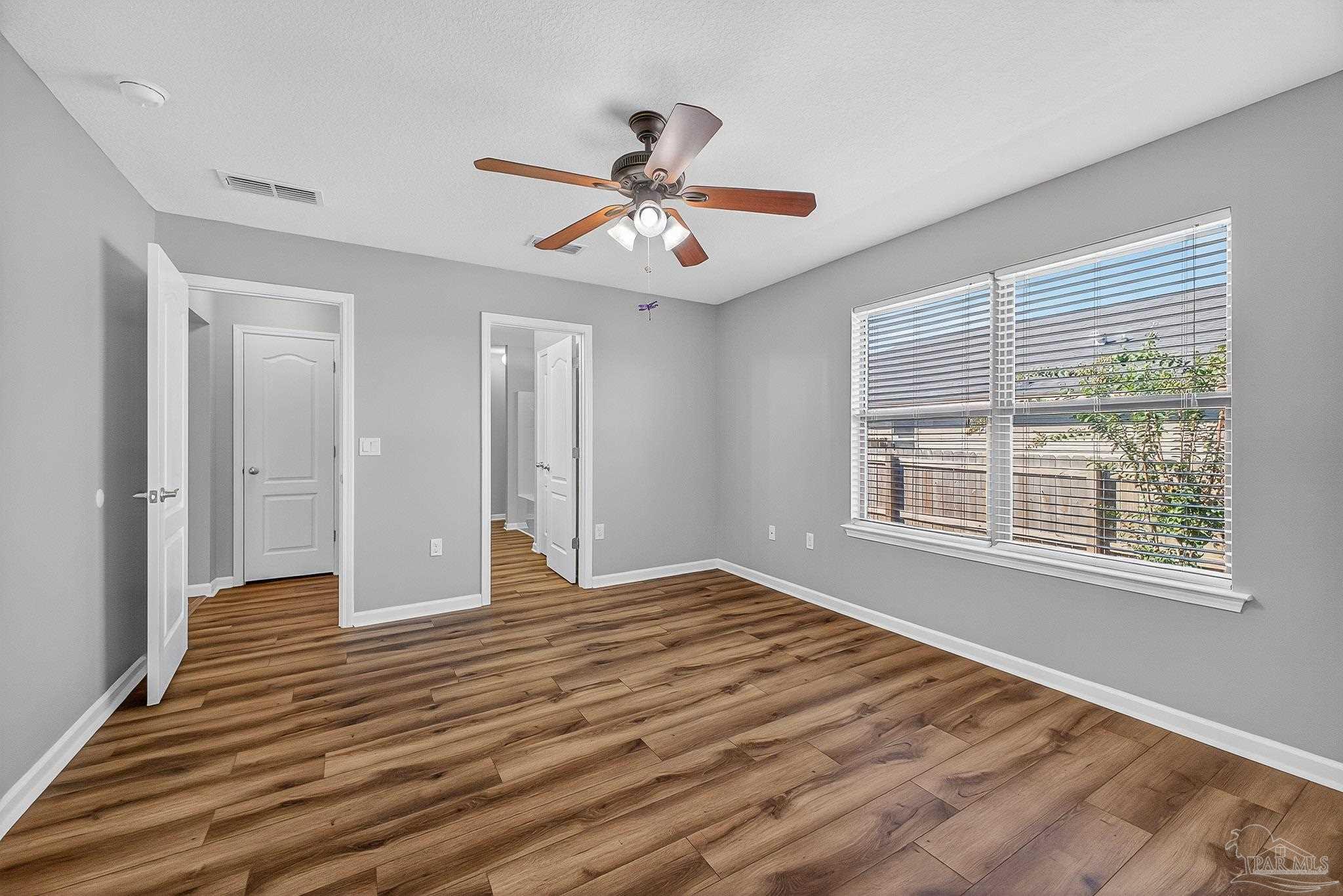 272 Millet Circle Cantonment, FL 32533 - Photo 40 of 57 a view of an empty room with wooden floor and a window