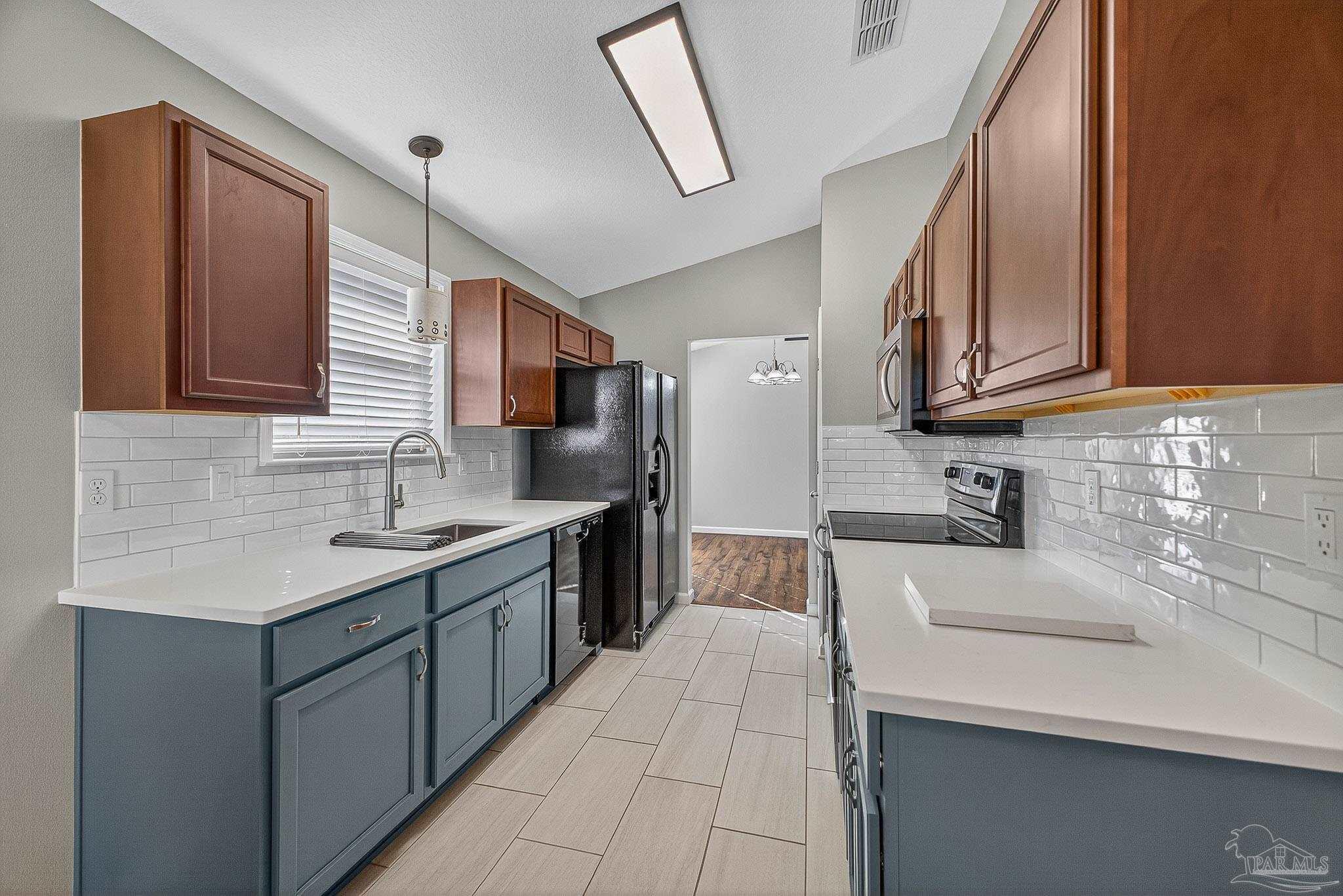 272 Millet Circle Cantonment, FL 32533 - Photo 4 of 57 a kitchen with stainless steel appliances a sink dishwasher stove refrigerator and cabinets