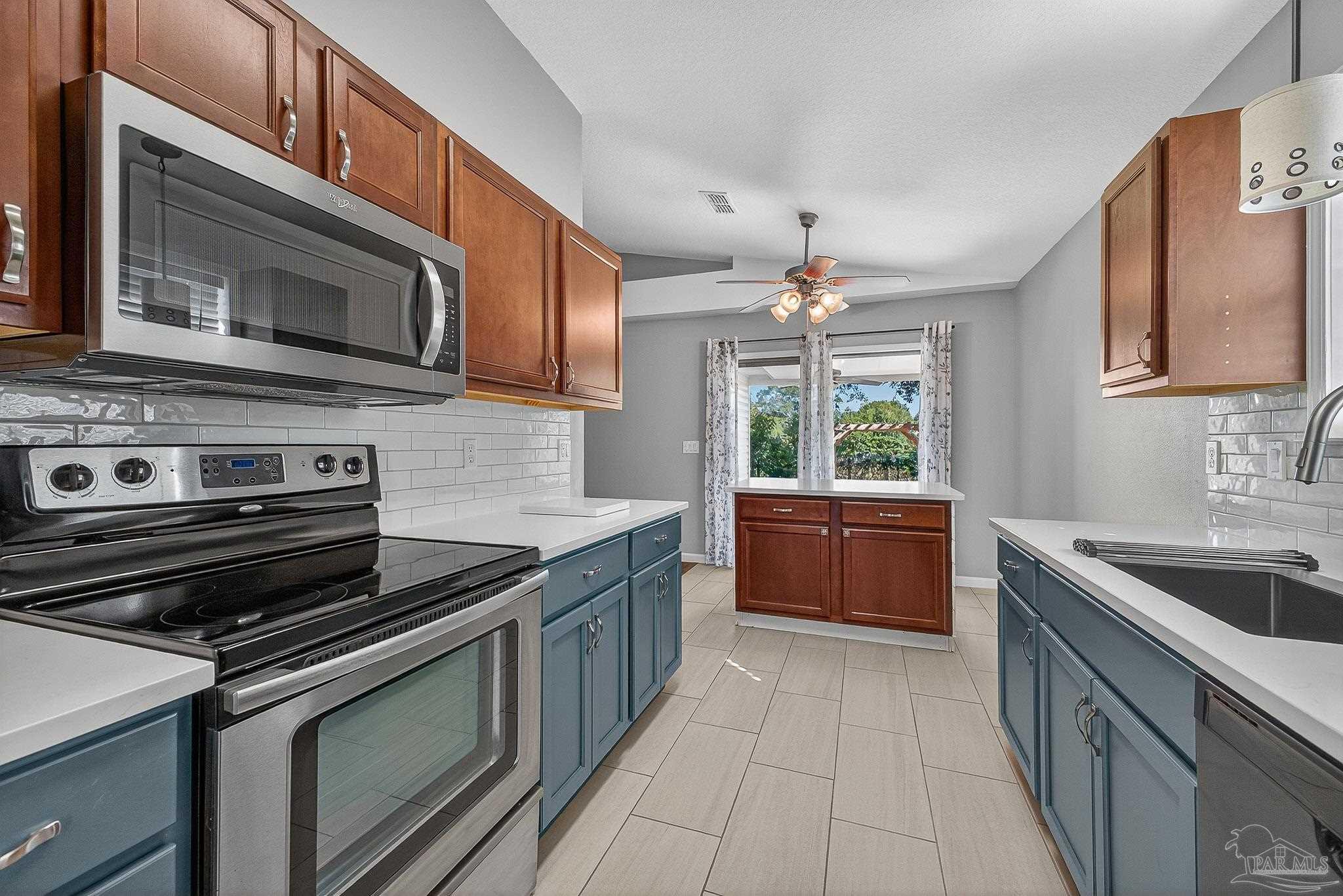 272 Millet Circle Cantonment, FL 32533 - Photo 5 of 57 a kitchen with a stove microwave and sink