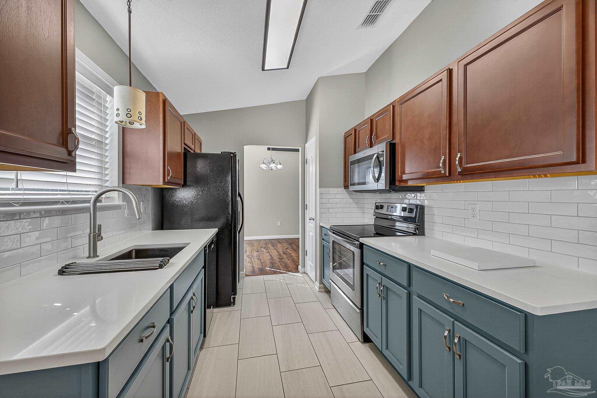 272 Millet Circle Cantonment, FL 32533 - Photo 6 of 57 a kitchen with stainless steel appliances granite countertop a sink stove and refrigerator