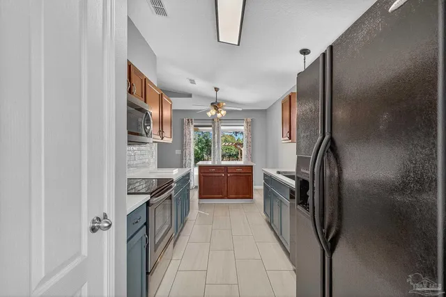 a kitchen with stainless steel appliances granite countertop a refrigerator and a stove