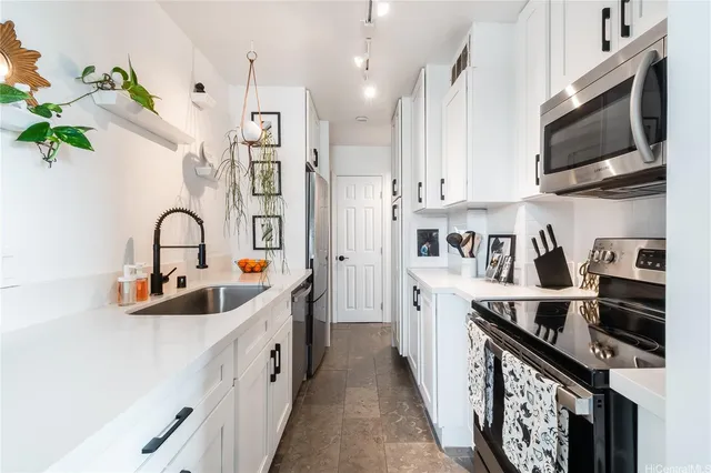 a kitchen with kitchen island stainless steel appliances a sink a stove and a center island