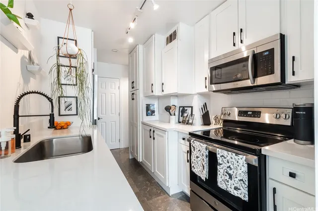 a kitchen with stainless steel appliances granite countertop a stove a sink and a microwave