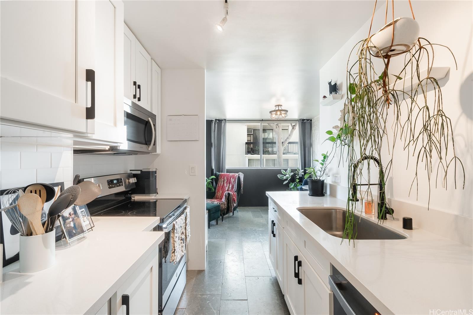 1069 Spencer Street, Unit 402 Honolulu, HI 96822 - Photo 6 of 16 a kitchen with stainless steel appliances a sink a stove top oven a counter space and cabinets