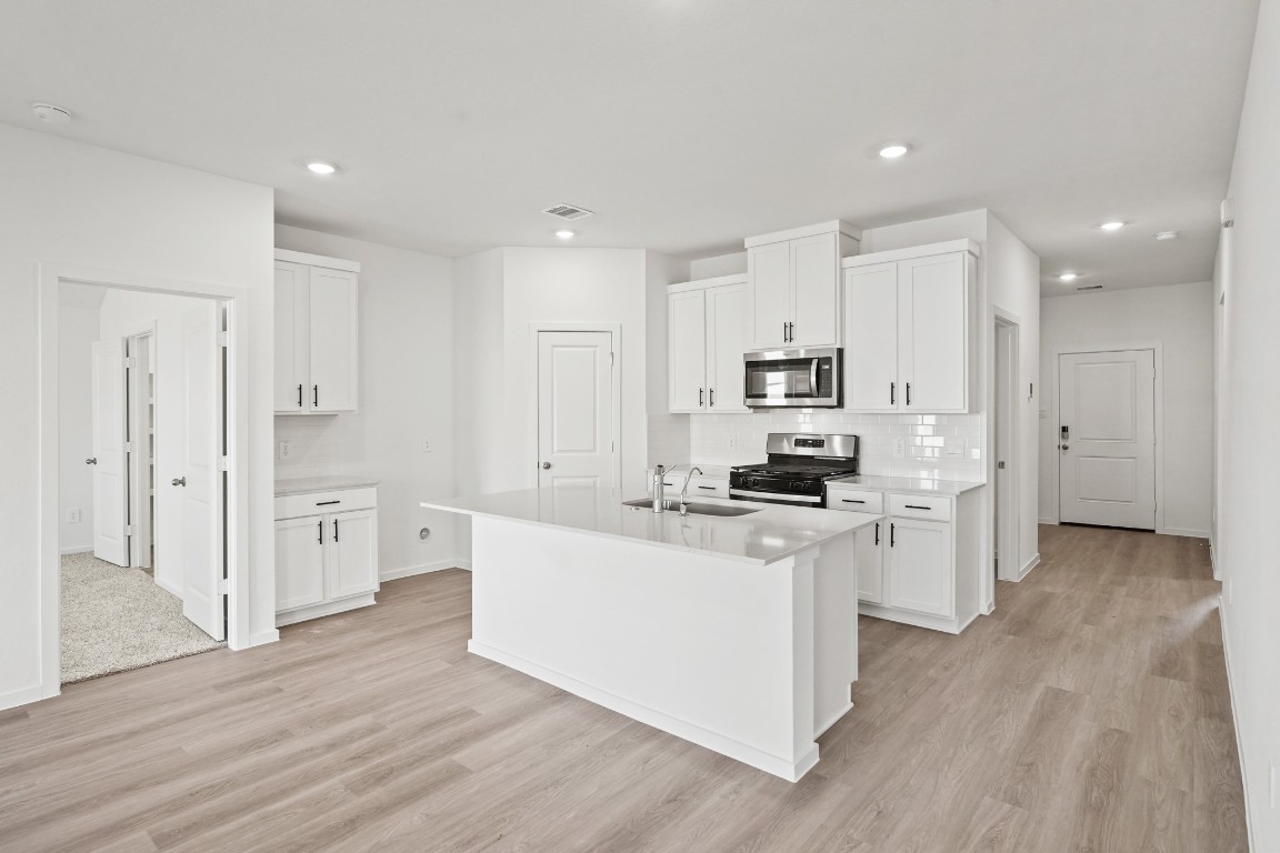 525 Wax Myrtle Way Hockley, TX 77447 - Photo 3 of 20 a kitchen with stainless steel appliances cabinets a wooden floor and a sink