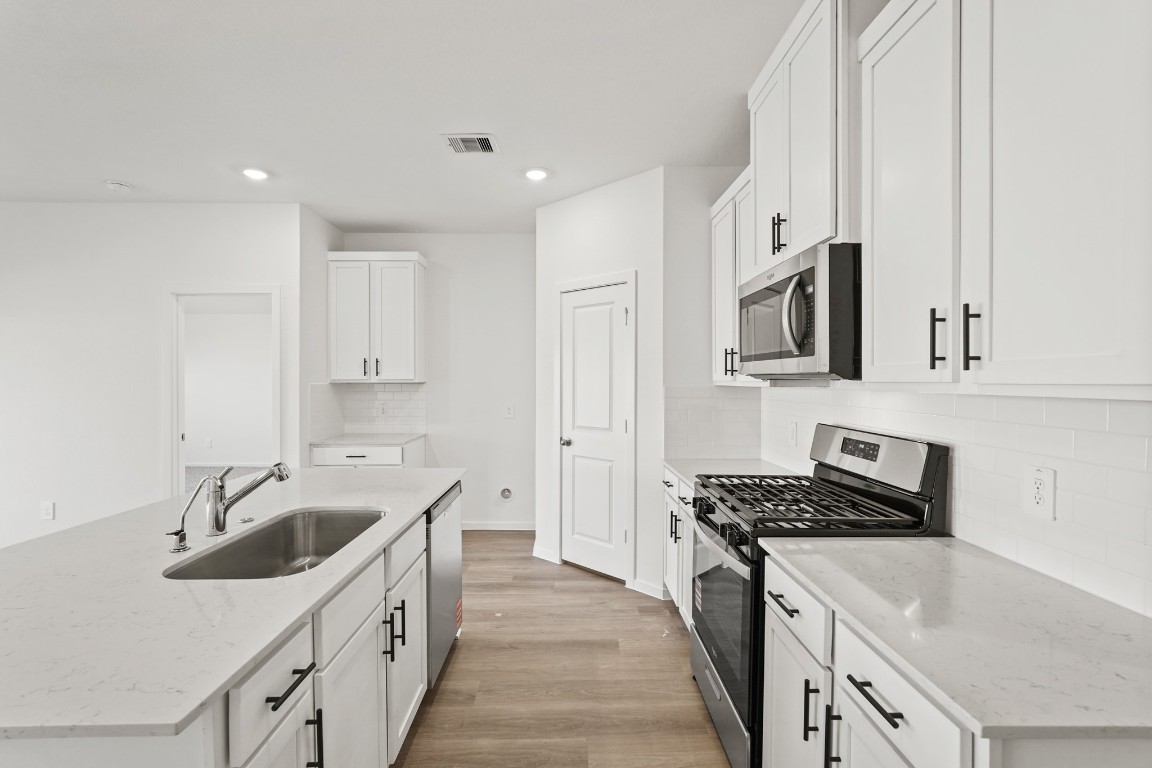 525 Wax Myrtle Way Hockley, TX 77447 - Photo 6 of 20 a kitchen with a sink stove top oven and cabinets