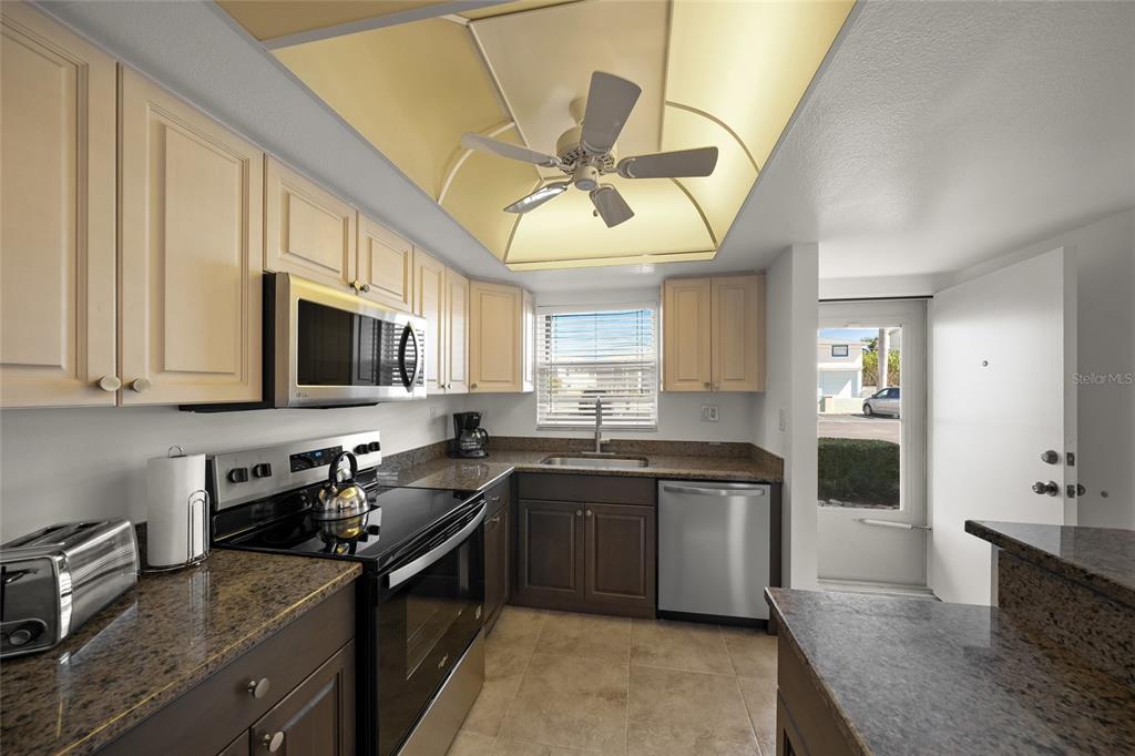 9200 Midnight Pass Road, Unit 17 Sarasota, FL 34242 - Photo 11 of 56 a kitchen with stainless steel appliances granite countertop a sink a stove top oven a counter space and cabinets