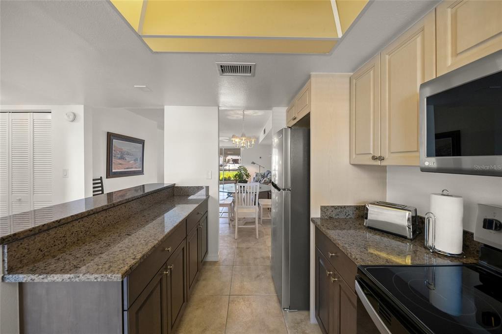 9200 Midnight Pass Road, Unit 17 Sarasota, FL 34242 - Photo 12 of 56 a kitchen with stainless steel appliances granite countertop a sink stove and refrigerator