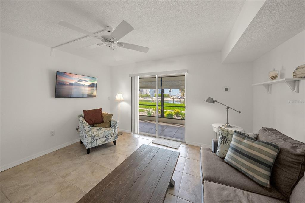9200 Midnight Pass Road, Unit 17 Sarasota, FL 34242 - Photo 15 of 56 a living room with furniture and a floor to ceiling window