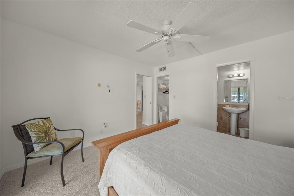 9200 Midnight Pass Road, Unit 17 Sarasota, FL 34242 - Photo 20 of 56 a bedroom with a bed and a chandelier