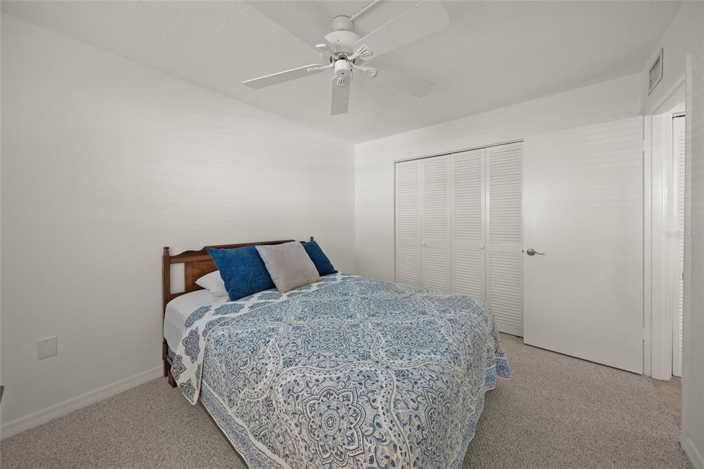 9200 Midnight Pass Road, Unit 17 Sarasota, FL 34242 - Photo 25 of 56 a bedroom with a bed and a chandelier