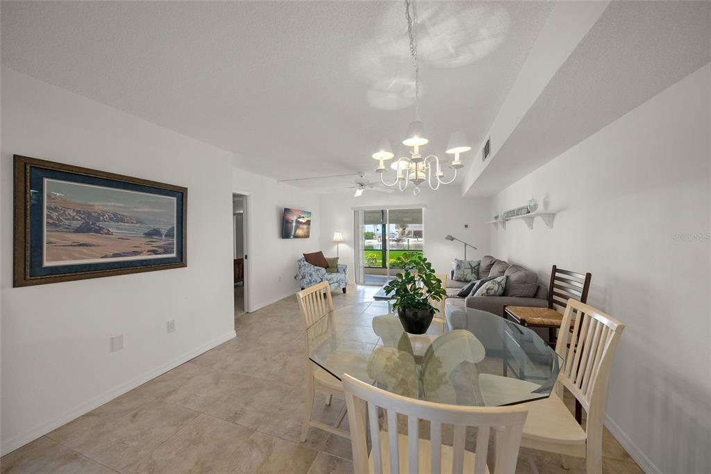 9200 Midnight Pass Road, Unit 17 Sarasota, FL 34242 - Photo 7 of 56 a dining room with furniture and chandelier