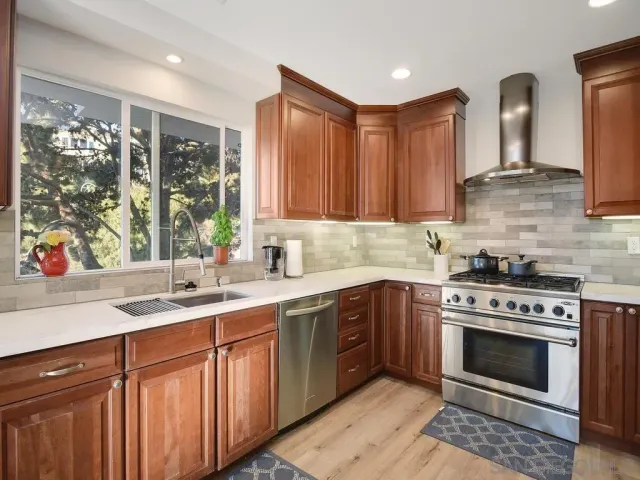 a kitchen with a stove sink and cabinets