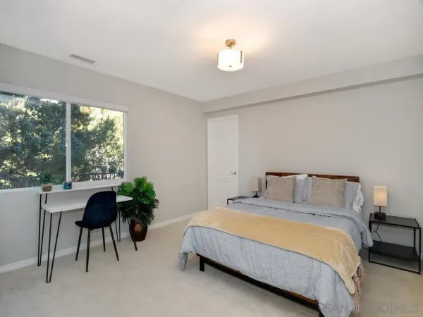 a bedroom with a bed and a potted plant