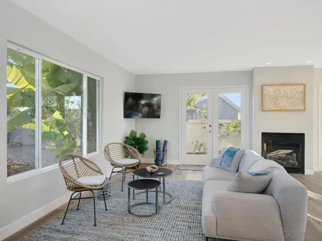 a living room with furniture a fireplace and a large window