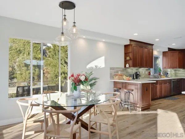 a dining room with granite countertop a table and chairs in it