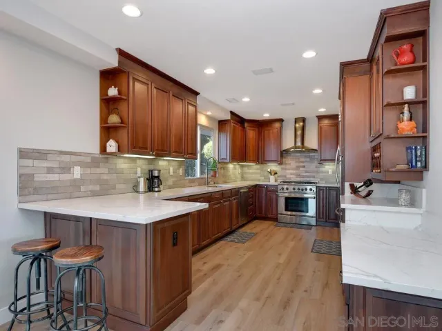 a kitchen with stainless steel appliances granite countertop wooden cabinets a sink and a stove