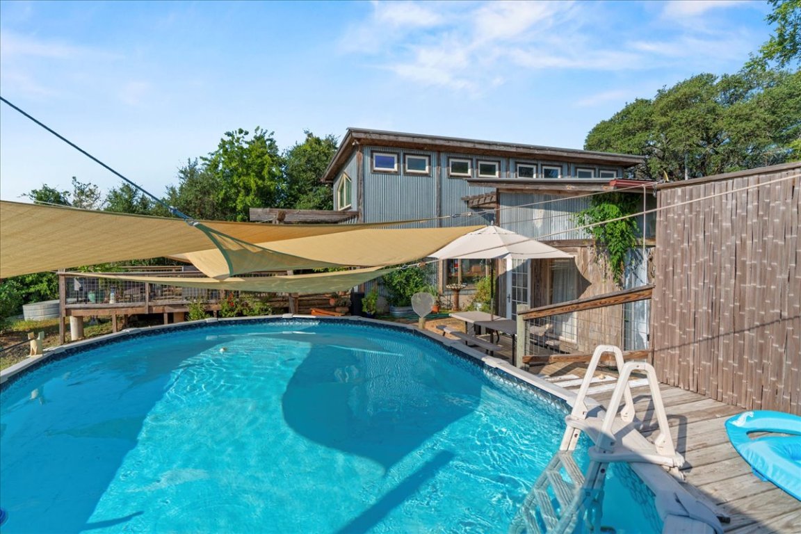 16933 B Ranch Road 12, Unit B Wimberley, TX 78676 - Photo 4 of 19 a view of a house with pool and chairs next to a yard