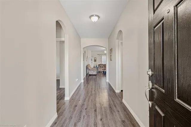a view of a hallway with wooden floor and staircase
