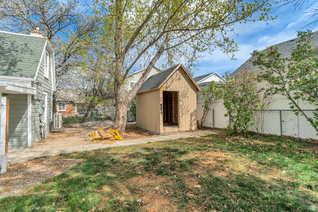 8831 South 400 East Sandy, UT 84070 - Photo 7 of 26 Fenced backyard with a patio area and a storage shed