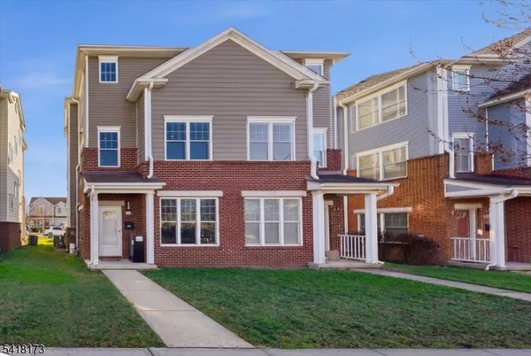 front view of a brick house with a yard