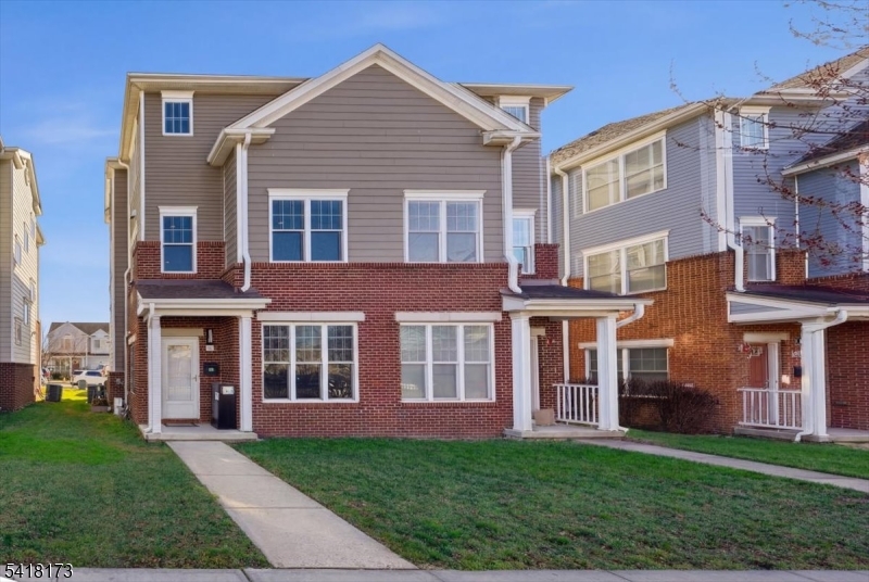 front view of a brick house with a yard