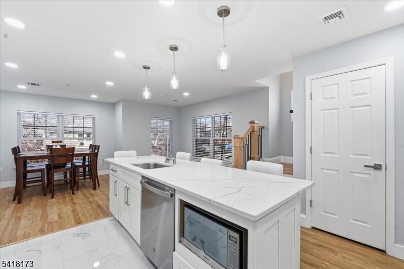 181 Court Street Newark, NJ 07103 - Photo 11 of 38 a open kitchen with stainless steel appliances granite countertop a table chairs and a refrigerator