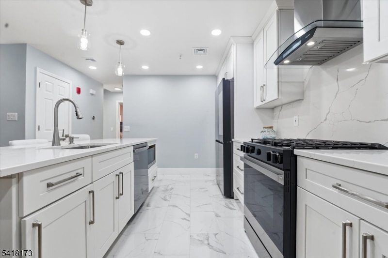 181 Court Street Newark, NJ 07103 - Photo 13 of 38 a kitchen with stainless steel appliances granite countertop a sink a stove and a refrigerator