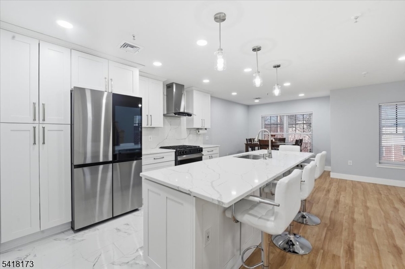 181 Court Street Newark, NJ 07103 - Photo 10 of 38 a large kitchen with kitchen island a refrigerator a stove a sink a dining table and chairs