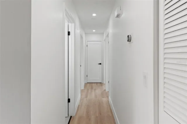 a view of a hallway with wooden floor