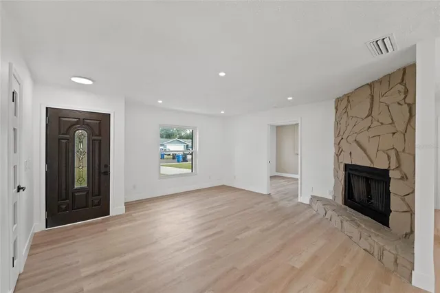 an empty room with windows and fireplace