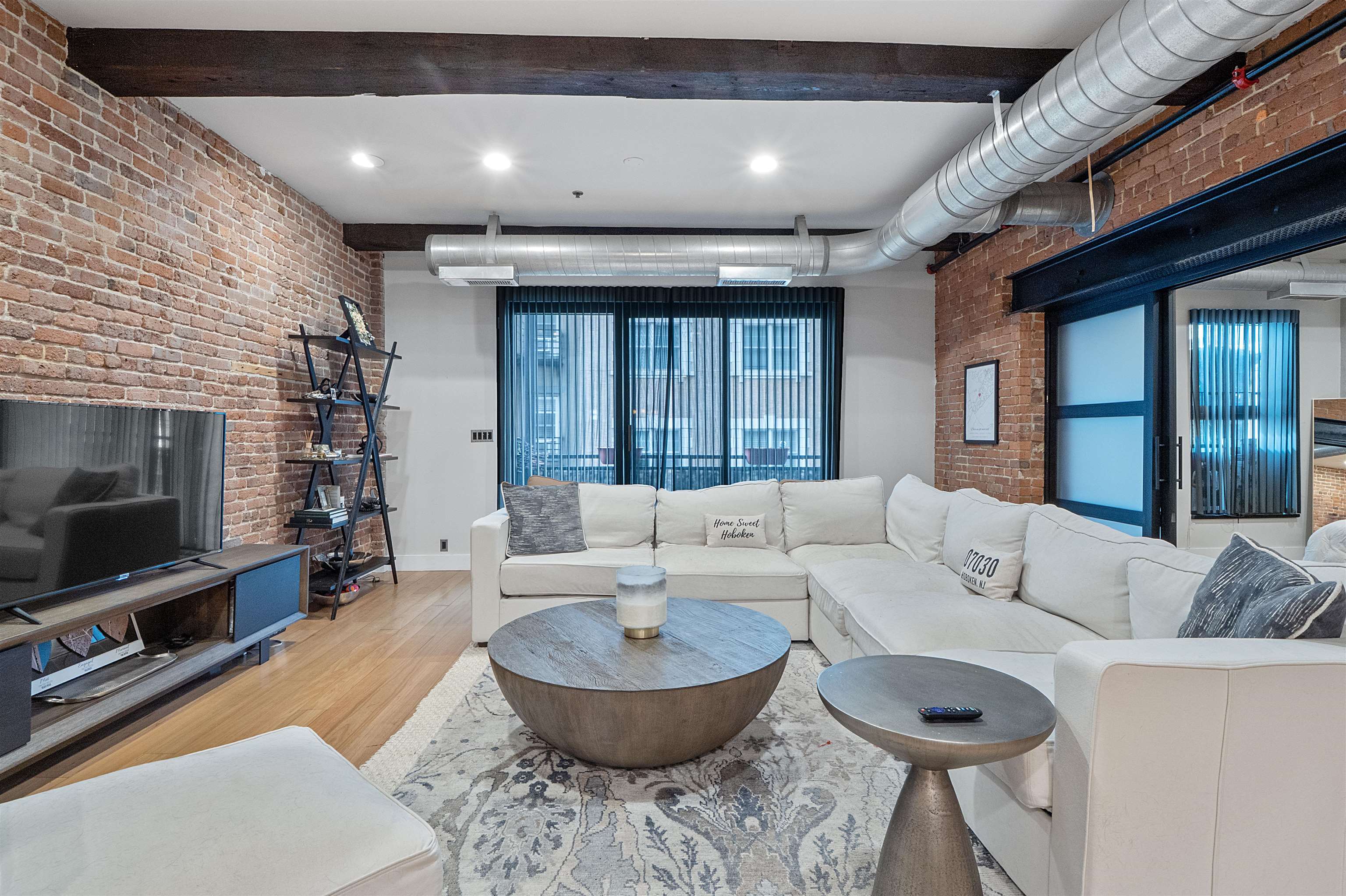 610 Clinton Street, Unit 2A Hoboken, NJ 07030 - Photo 19 of 33 a living room with furniture a flat screen tv and a fireplace