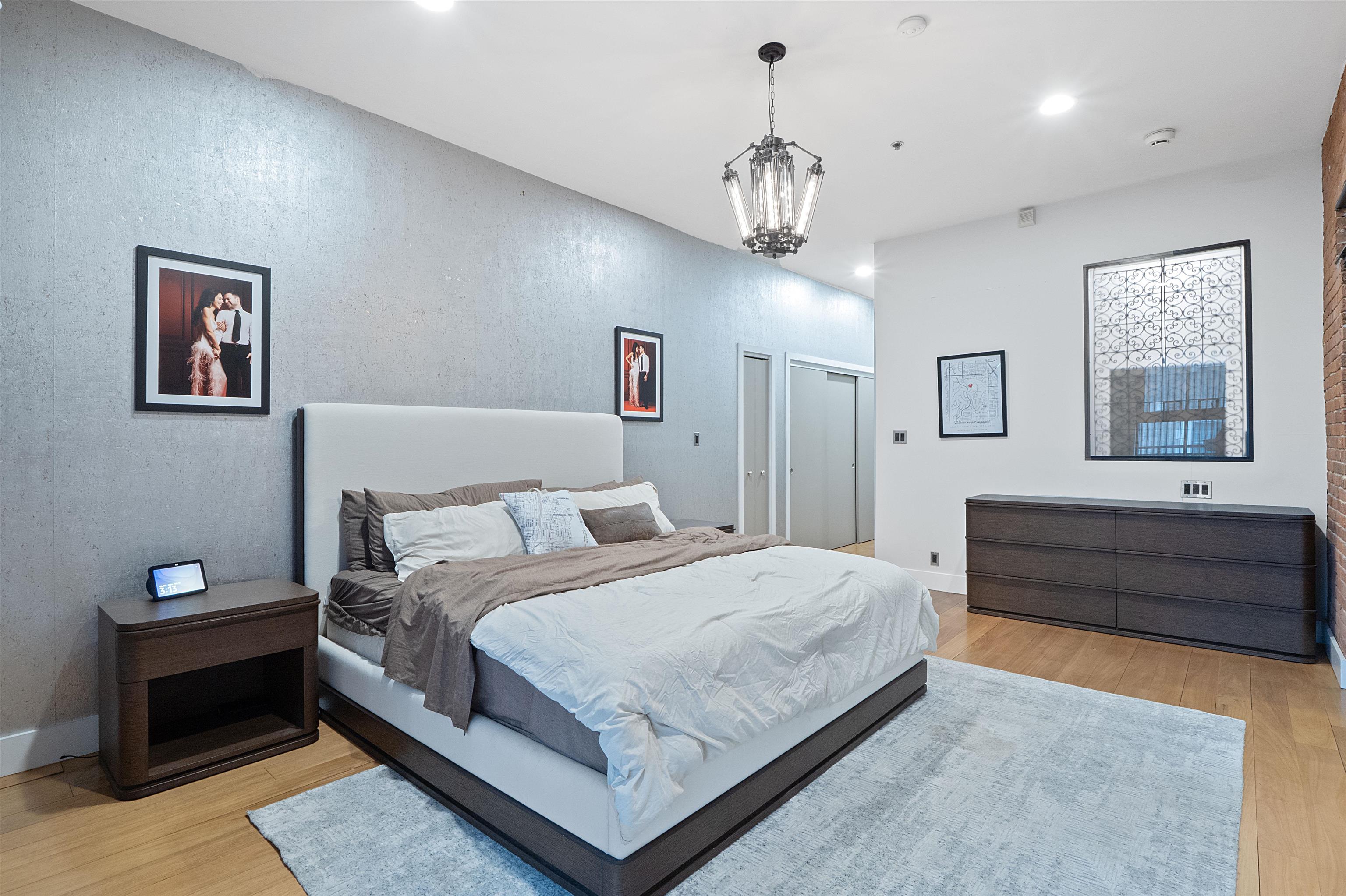 610 Clinton Street, Unit 2A Hoboken, NJ 07030 - Photo 25 of 33 a bedroom with a large bed and a chandelier