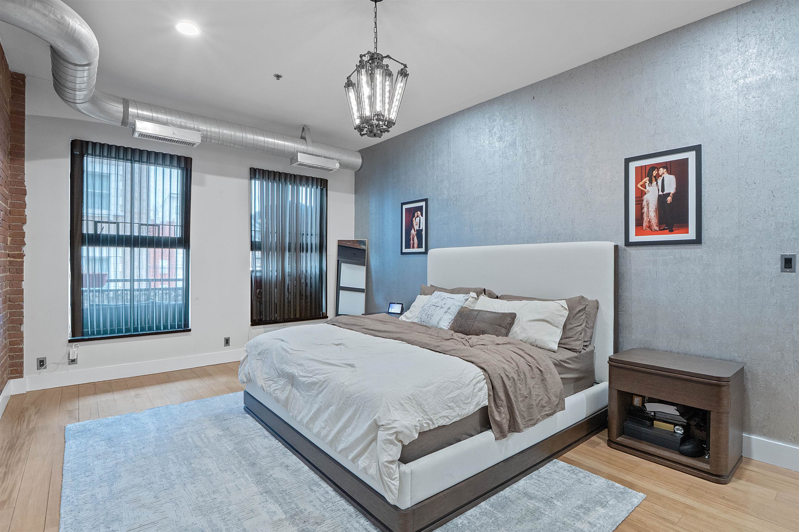 610 Clinton Street, Unit 2A Hoboken, NJ 07030 - Photo 26 of 33 a bedroom with a large bed and a chandelier