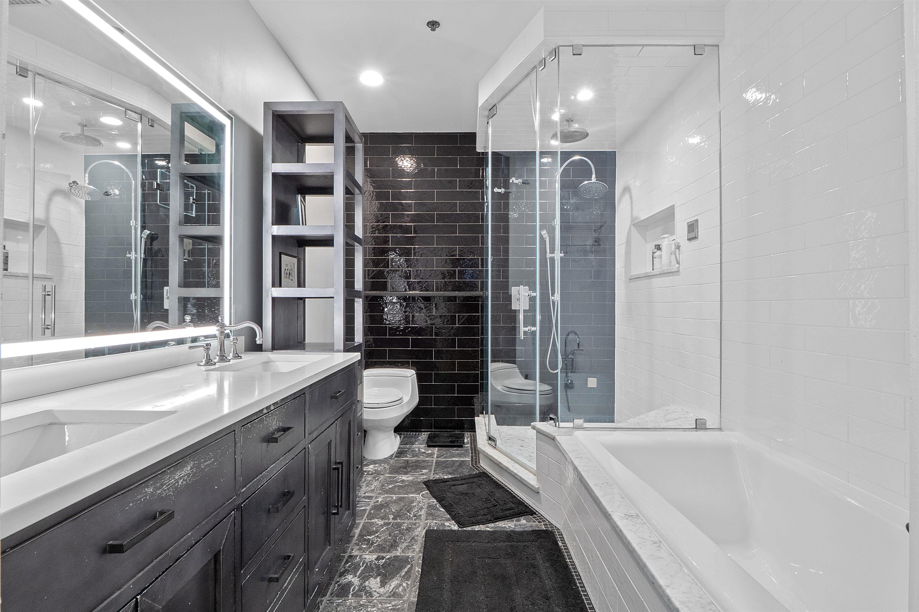 610 Clinton Street, Unit 2A Hoboken, NJ 07030 - Photo 28 of 33 a bathroom with a granite countertop sink a toilet a bathtub and shower